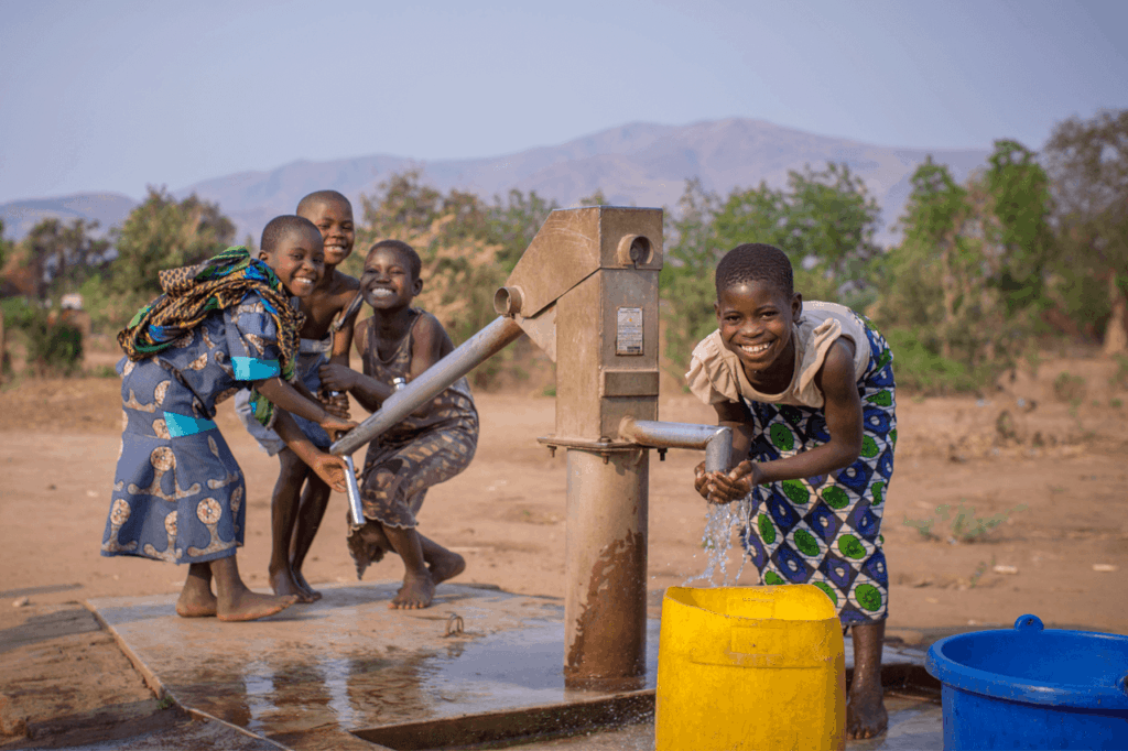 Children playing by hand pump