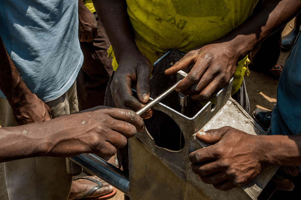 Men fixing a community borehole