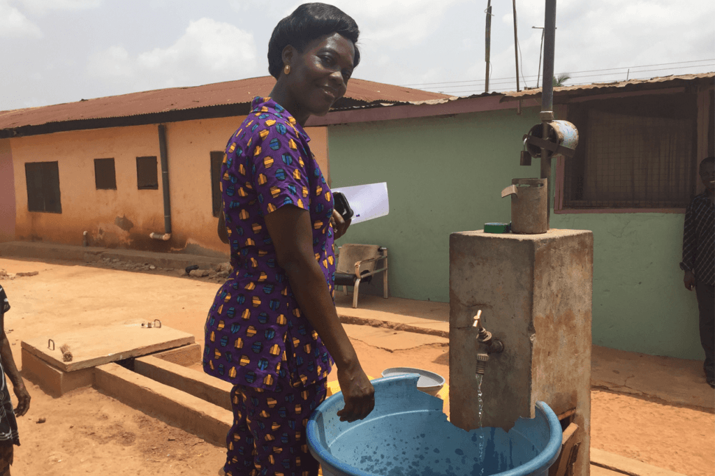 Woman collecting water from community tap