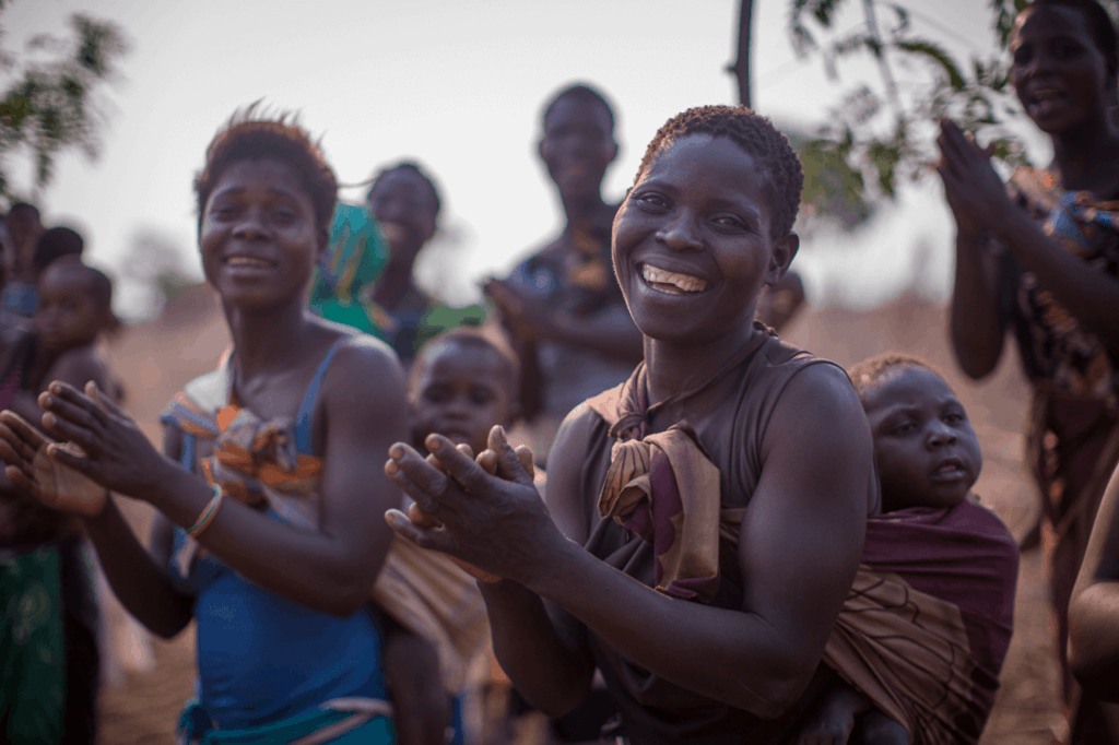 Woman and children clapping hands and looking happy